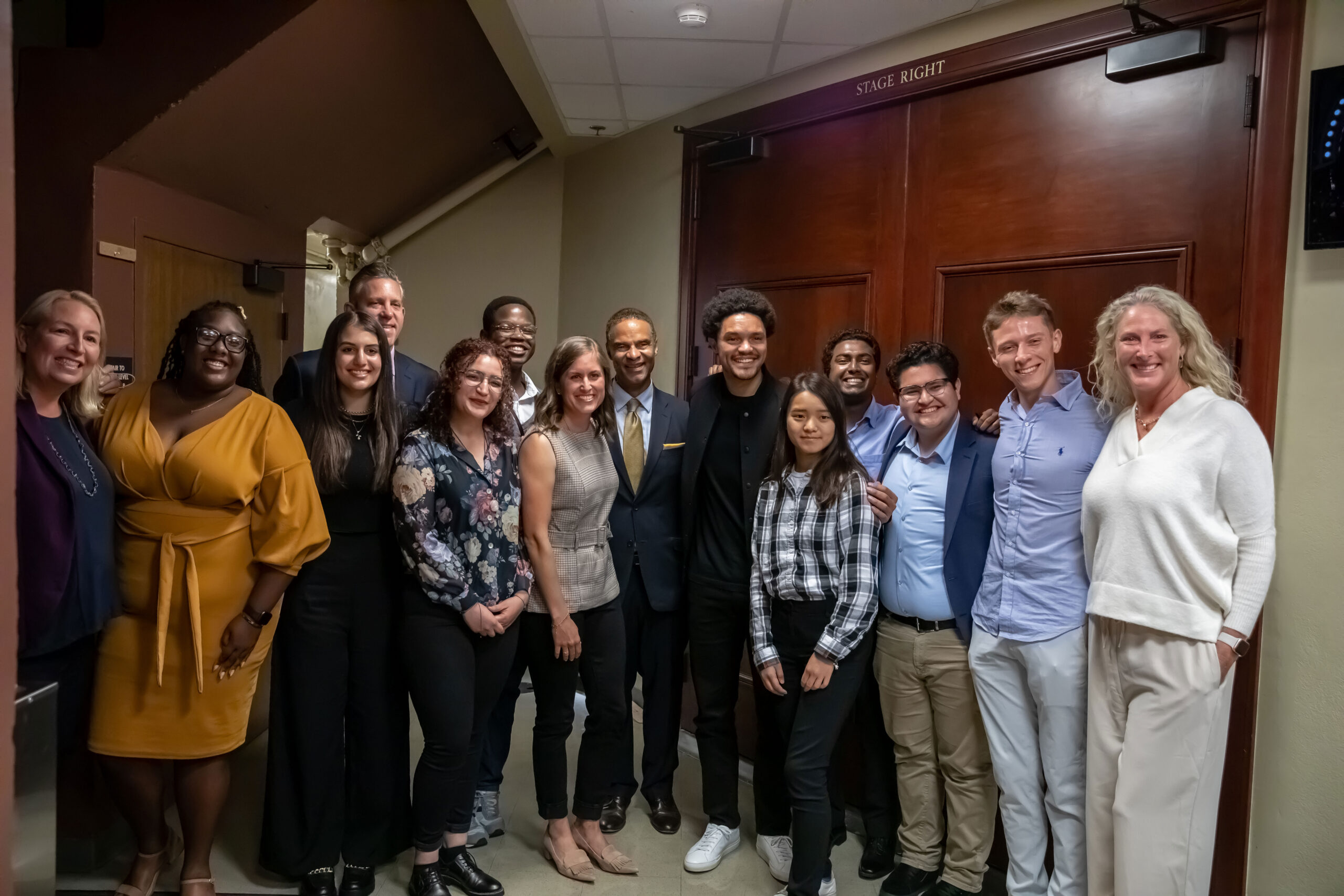 Alec Gallimore, Dean of Engineering, and Trevor Noah pose for photo with students from Michigan Engineering